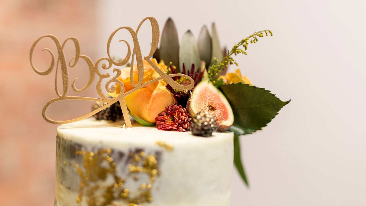 Cake topper cut out of wood with initials "B" and "R"